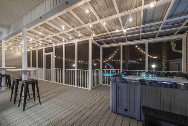 deck at night with a hot tub