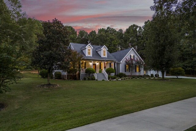 cape cod home with a front lawn and a porch