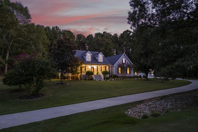 new england style home with a yard and covered porch