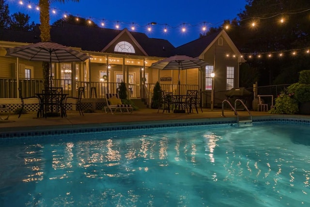 view of pool at twilight