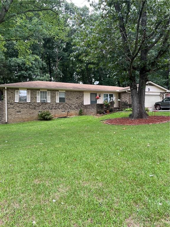 single story home featuring a garage and a front yard