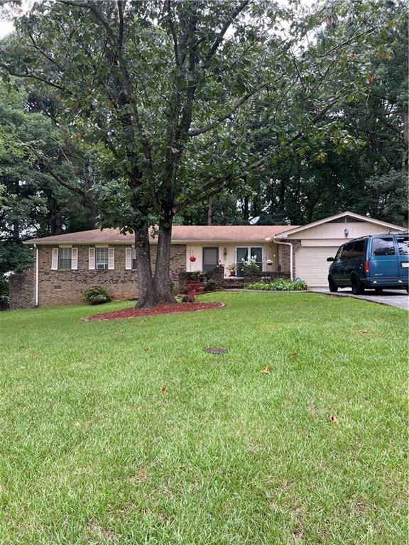 ranch-style home with a garage, driveway, and a front yard