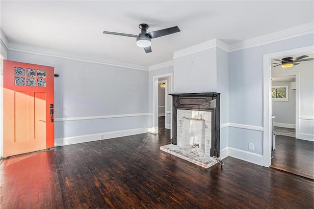 unfurnished living room with baseboards, ornamental molding, a fireplace with raised hearth, and wood finished floors