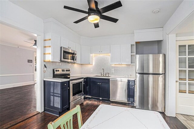 121 Norris St, Monroe, GA 30655 - kitchen with appliances with stainless steel finishes, washer / clothes dryer, blue cabinets, light countertops, and a sink