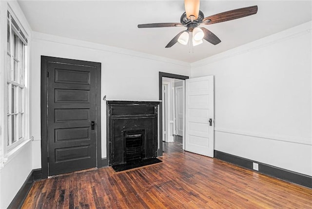 unfurnished living room featuring ceiling fan, crown molding, baseboards, and wood finished floors