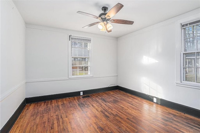 unfurnished room featuring a ceiling fan, dark wood-style flooring, visible vents, and baseboards