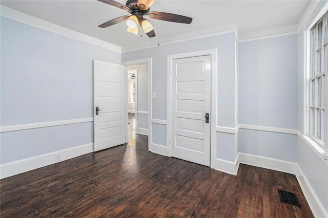 unfurnished room with baseboards, visible vents, a ceiling fan, wood finished floors, and crown molding