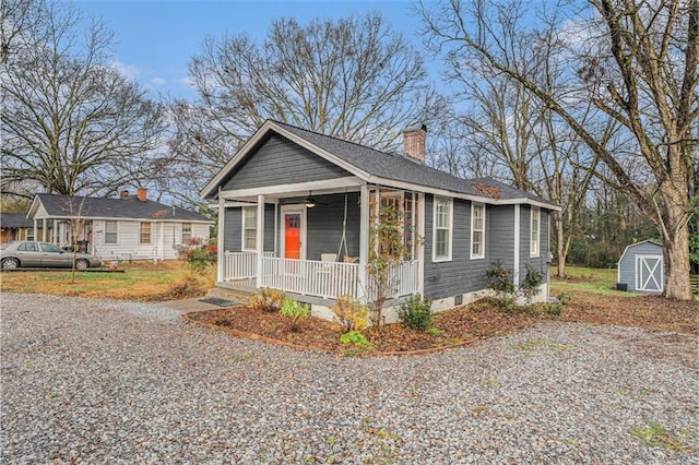 bungalow-style house featuring driveway, a storage shed, an outbuilding, crawl space, and covered porch