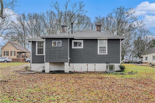 rear view of property featuring central AC and a chimney