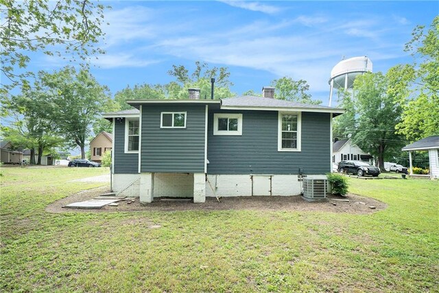 121 Norris St, Monroe, GA 30655 - back of property with crawl space, a yard, a chimney, and central air condition unit