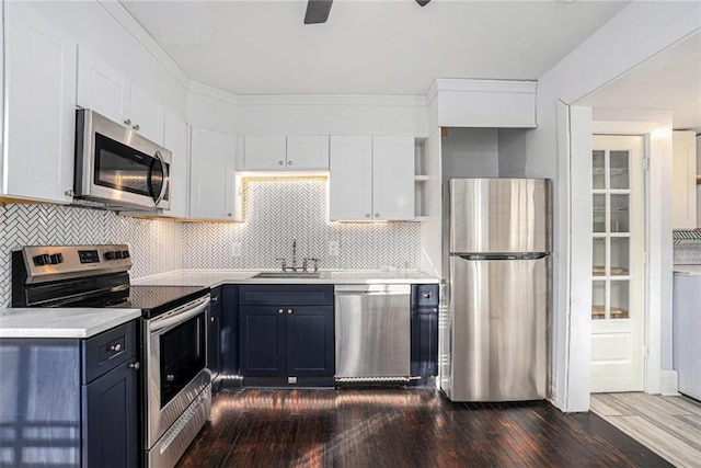 kitchen with stainless steel appliances, white cabinets, light countertops, and a sink