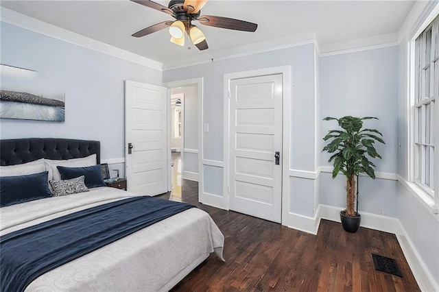 bedroom featuring visible vents, crown molding, baseboards, and wood finished floors