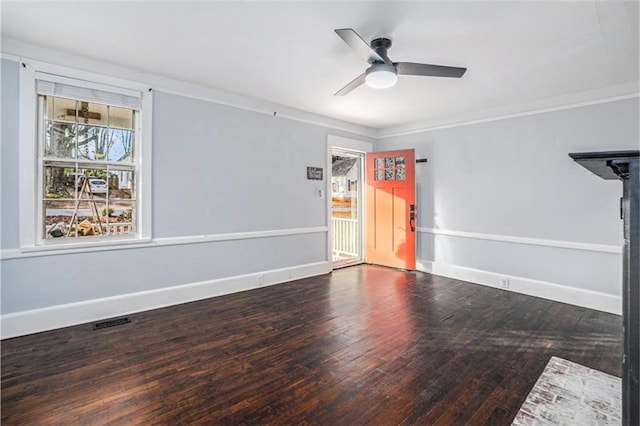 unfurnished room with hardwood / wood-style flooring, baseboards, visible vents, and a ceiling fan