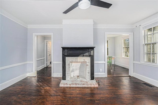 unfurnished living room featuring a brick fireplace, visible vents, crown molding, and wood finished floors