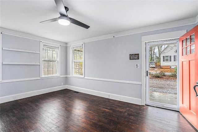 unfurnished room with dark wood-style floors, crown molding, and baseboards