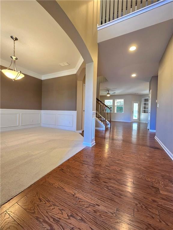 empty room with ceiling fan, dark hardwood / wood-style flooring, and crown molding