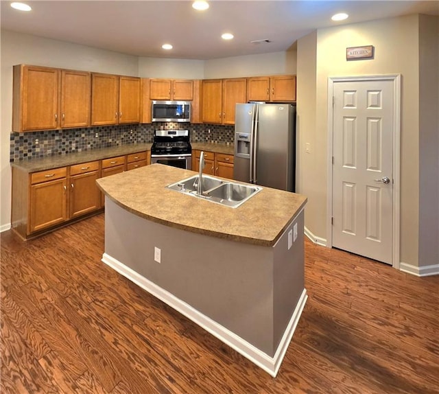 kitchen featuring sink, appliances with stainless steel finishes, dark hardwood / wood-style flooring, and a kitchen island with sink