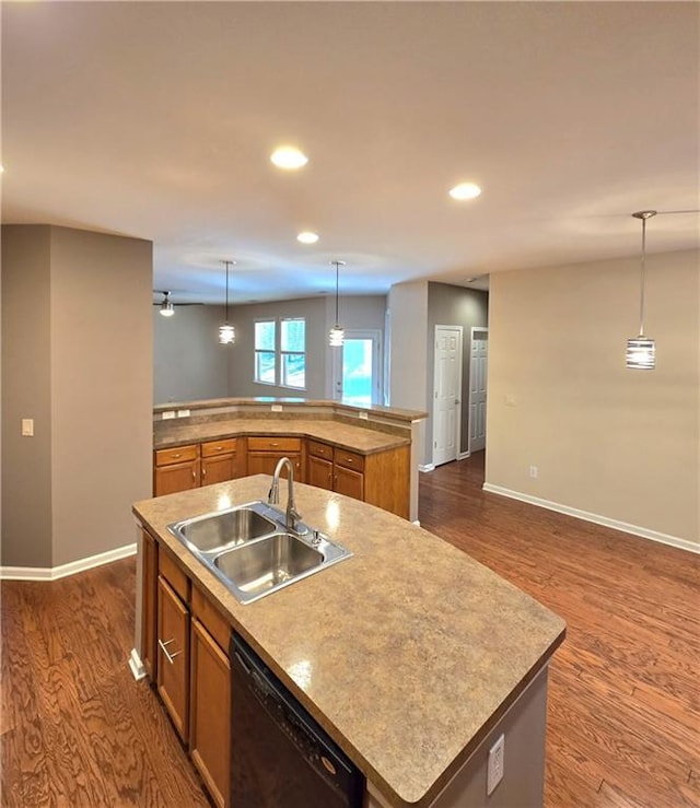 kitchen with decorative light fixtures, sink, black dishwasher, and a center island with sink