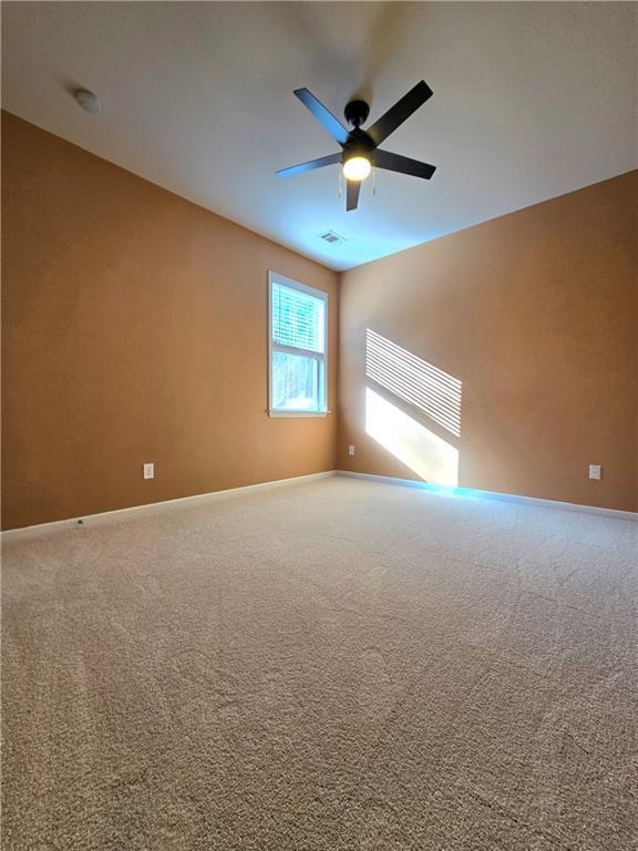 carpeted empty room featuring ceiling fan