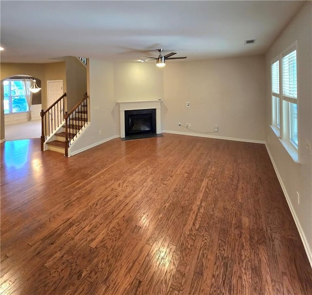 unfurnished living room with ceiling fan and dark hardwood / wood-style flooring