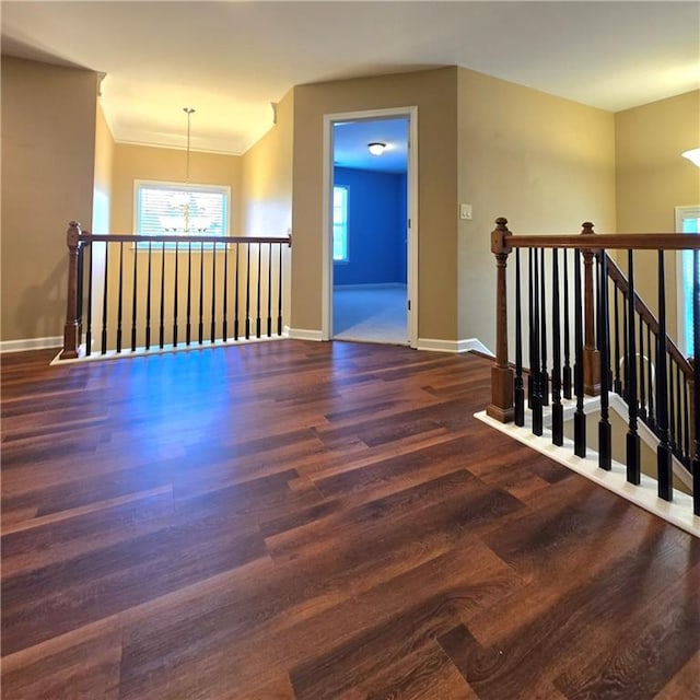 empty room featuring dark hardwood / wood-style floors and an inviting chandelier