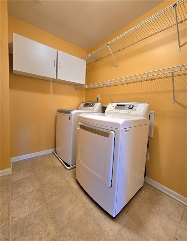 laundry room featuring cabinets and washing machine and dryer