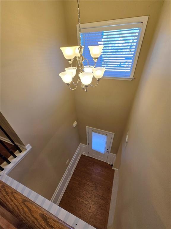 stairs with an inviting chandelier and hardwood / wood-style floors