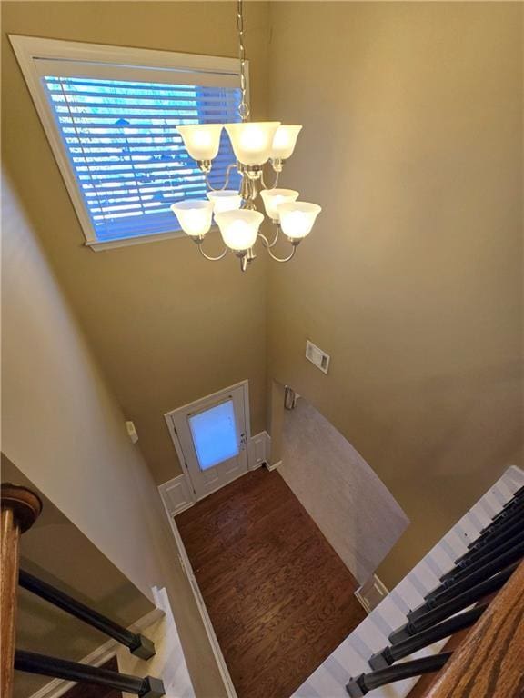 interior space featuring hardwood / wood-style flooring, a high ceiling, and a notable chandelier