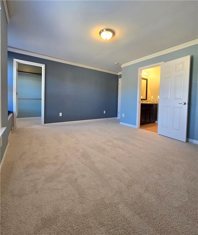 interior space with light carpet, connected bathroom, and ornamental molding