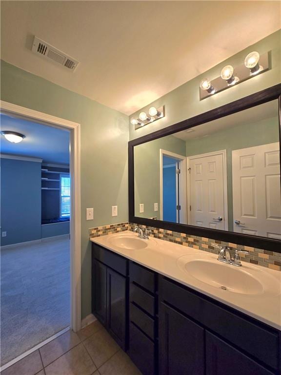 bathroom featuring tile patterned floors, vanity, and tasteful backsplash