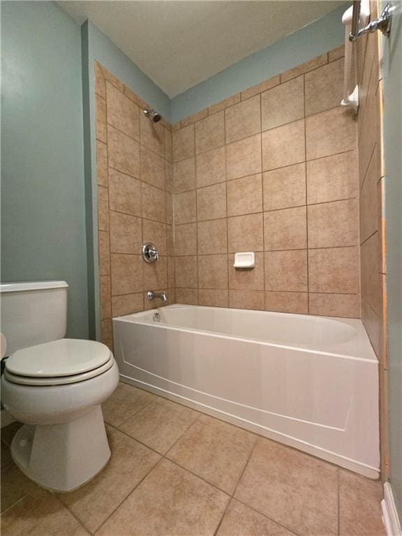 bathroom featuring toilet, tile patterned floors, and tiled shower / bath