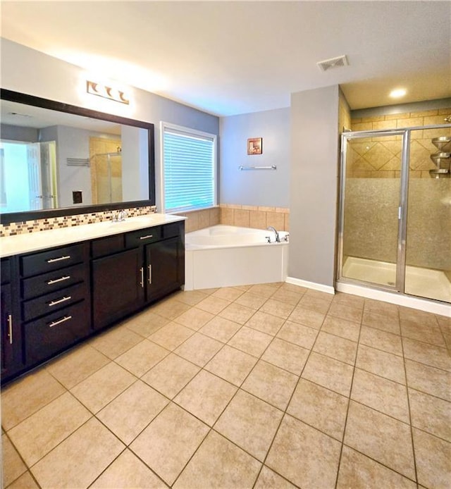 bathroom featuring shower with separate bathtub, vanity, and tile patterned flooring