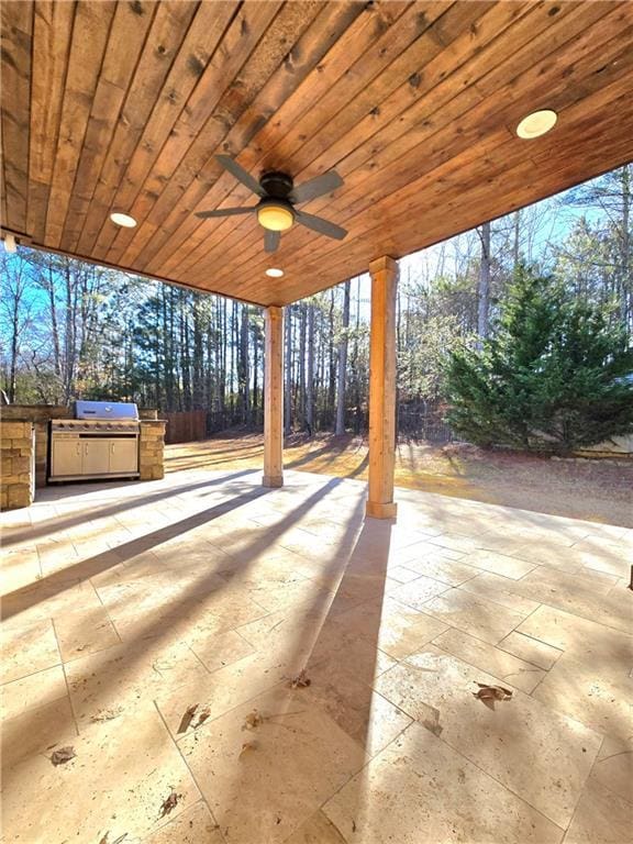 view of patio / terrace with ceiling fan, exterior kitchen, and a grill