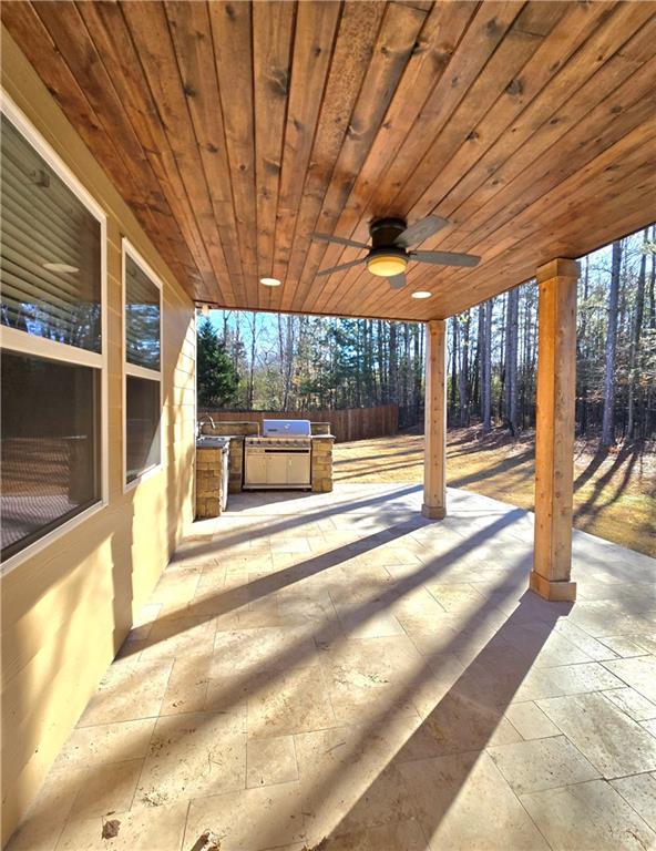 view of patio / terrace featuring ceiling fan and an outdoor kitchen