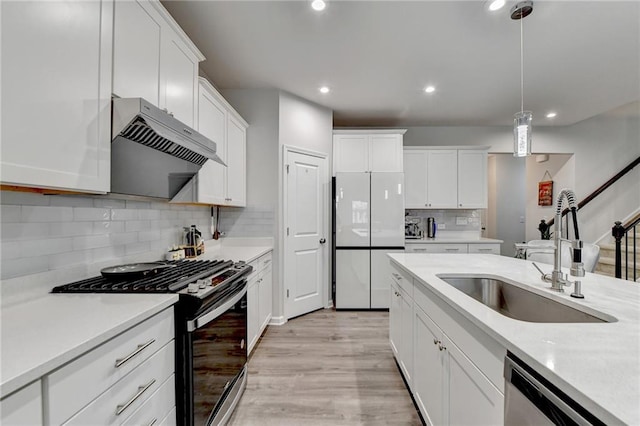 5452 Fountainhead Ln, Auburn, GA 30011 - kitchen with freestanding refrigerator, black range with gas stovetop, under cabinet range hood, a sink, and dishwasher