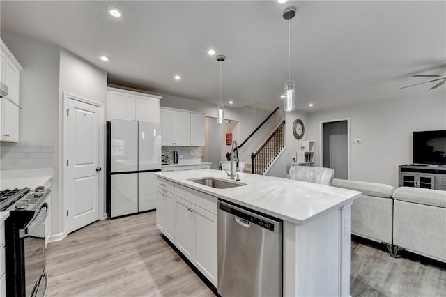 5452 Fountainhead Ln, Auburn, GA 30011 - kitchen featuring stainless steel dishwasher, a sink, freestanding refrigerator, black range with gas stovetop, and open floor plan