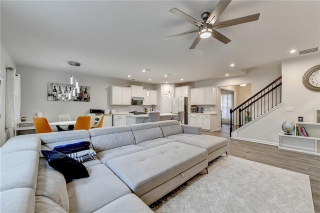 5452 Fountainhead Ln, Auburn, GA 30011 - living area featuring ceiling fan, light wood-style floors, recessed lighting, visible vents, and stairway