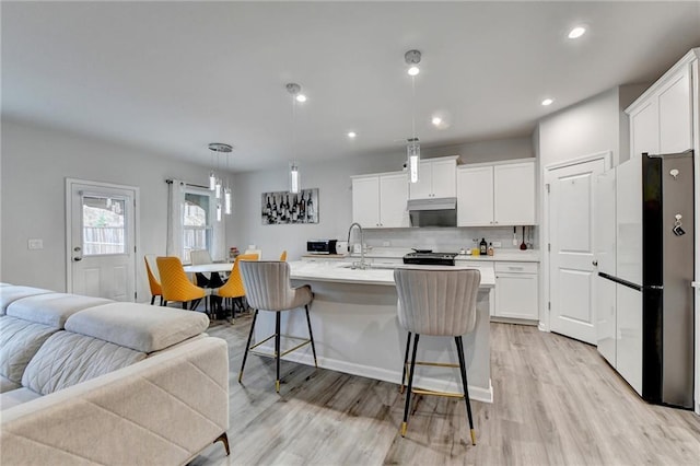 5452 Fountainhead Ln, Auburn, GA 30011 - kitchen with freestanding refrigerator, light wood finished floors, white cabinetry, and open floor plan
