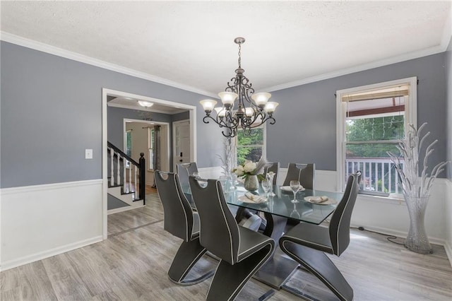 1433 Janice Ct SW, Lilburn, GA 30047 - dining area with a chandelier, wood finished floors, stairway, ornamental molding, and a textured ceiling