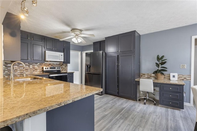 1433 Janice Ct SW, Lilburn, GA 30047 - kitchen featuring appliances with stainless steel finishes, decorative backsplash, ceiling fan, a desk, and light wood-style floors