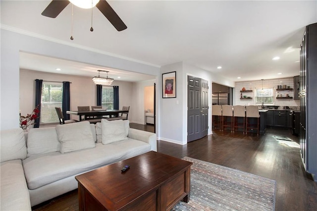 living room featuring baseboards, ornamental molding, dark wood-style flooring, and recessed lighting