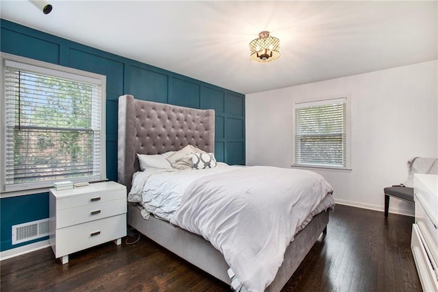 bedroom featuring baseboards, visible vents, and dark wood finished floors