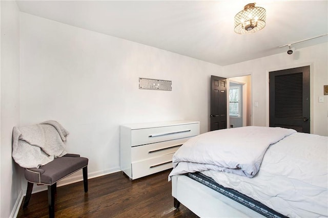 bedroom with baseboards and dark wood-type flooring