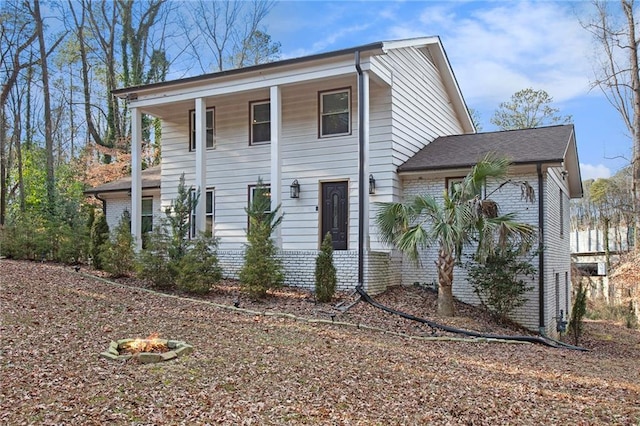 view of front of home featuring brick siding and an outdoor fire pit