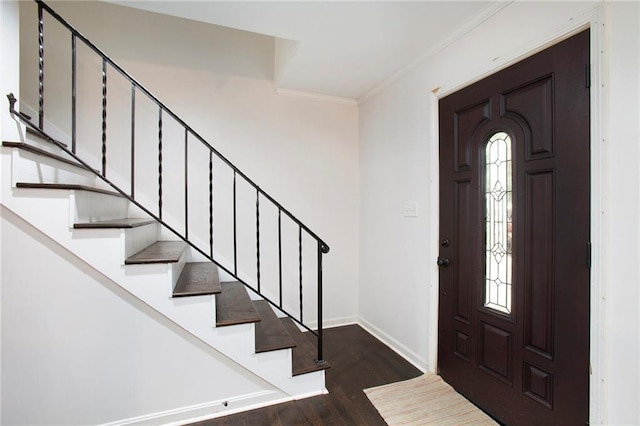 entrance foyer featuring ornamental molding, dark wood finished floors, stairway, and baseboards