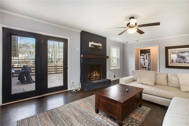 living area featuring ornamental molding, a fireplace, and wood finished floors