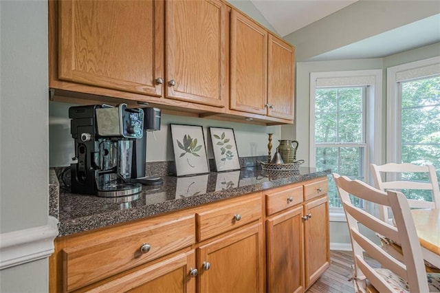 115 Oak Crest Ln, Dallas, GA 30132 - kitchen featuring dark stone countertops, light wood-type flooring, and vaulted ceiling