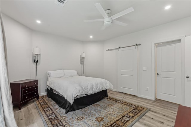 7540 Shadburn Ferry Rd, Cumming, GA 30041 - bedroom featuring light wood-style floors, a barn door, recessed lighting, a ceiling fan, and baseboards