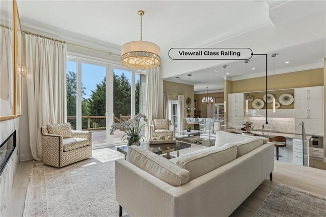 7540 Shadburn Ferry Rd, Cumming, GA 30041 - living room featuring wood finished floors, ornamental molding, recessed lighting, a chandelier, and a glass covered fireplace