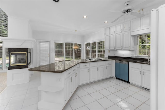 kitchen featuring light tile patterned floors, stainless steel dishwasher, a multi sided fireplace, and ceiling fan